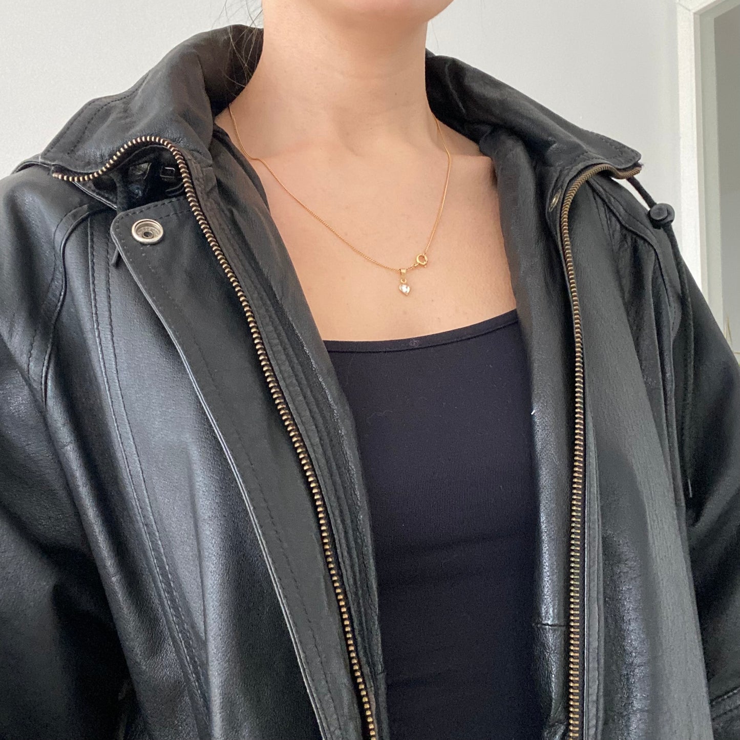 black leather jacket featuring a hood and zippered front closure.