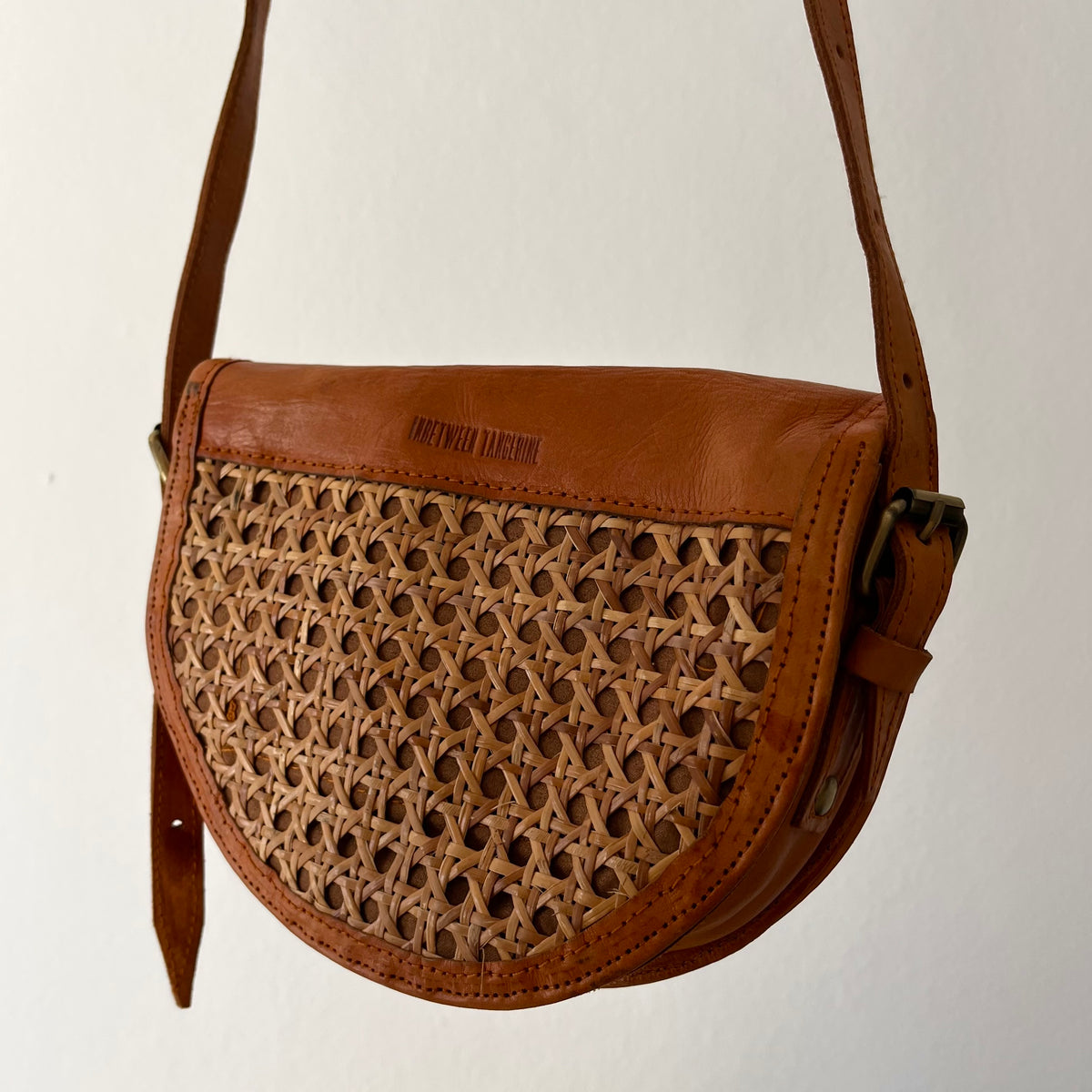 Tan leather half-moon crossbody bag
